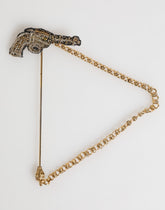 Broche Dolce & Gabbana en laiton et cuivre, représentant un revolver. Accessoire homme.