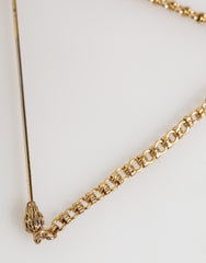 Broche Dolce & Gabbana en laiton et cuivre, représentant un revolver. Accessoire homme.