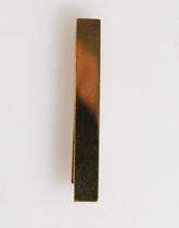 Pince à cravate Dolce & Gabbana en laiton doré avec logo, accessoire pour homme.