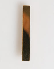 Pince à cravate Dolce & Gabbana en laiton doré avec logo, accessoire pour homme.