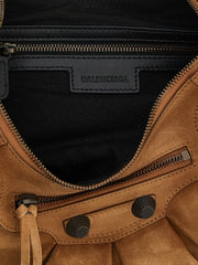 Close-up detail of the Balenciaga brown shoulder bag, focusing on the premium calfskin grain and hardware craftsmanship.