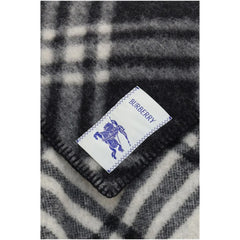Detailný pohľad na sivý vlnený šál Burberry, ktorý zvýrazňuje zložité pletenie, hotové okraje a autentické označenie značky.
