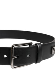 Close-up van de zilverkleurige metalen gesp en de ingewikkelde studding op de zwarte leren riem van Dolce & Gabbana.
