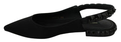 Profil latéral des chaussures plates en charmeuse noire Dolce & Gabbana montrant la bride à brides arrière délicate et la silhouette élégante.