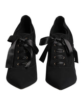 Dolce & Gabbana black lace-up stiletto pumps featuring a pointed toe and elegant wrap-around ankle ties.