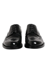 Dolce & Gabbana black calfskin leather wingtip Derby shoes featuring classic brogue perforations and lace-up closure.