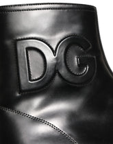 Dolce & Gabbana men's black leather ankle boots with embossed logo and side zipper, front three-quarter view.