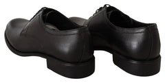 Perfil lateral dos sapatos formais pretos Dolce & Gabbana em couro, destacando a silhueta elegante e o salto empilhado.