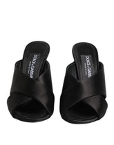 Dolce & Gabbana Keira black satin slides featuring a gold-tone DG logo plaque on the front strap.