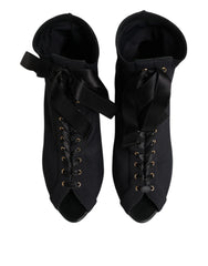 Side profile of Dolce & Gabbana stiletto ankle boots in black leather with intricate lacing and a slim high heel.
