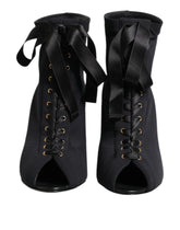 Dolce & Gabbana black leather ankle boots featuring a pointed toe, lace-up front, and elegant stiletto heel.