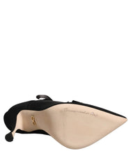 Schräger Blick auf luxuriöse Dolce & Gabbana schwarze Stiefel, die die raffinierte spitz zulaufende Zehenpartie und die hochwertige Stoffveredelung betonen.