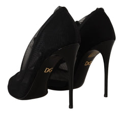 Oldalnézet a Dolce & Gabbana áttetső hálós cipőkön, amelyek vékony stiletto sarokkal és elegáns sziluettel rendelkeznek.