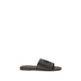 Dolce & Gabbana brown calf leather Bos Taurus flat sandals featuring a minimalist T-strap design and gold-tone hardware.