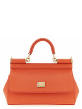 Frontvy av en Dolce & Gabbana orange handväska i kalvskinn med en strukturerad topphandtag och guldtonade beslag.