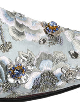 Dolce & Gabbana men's white leather loafers featuring intricate floral embellishments and slip-on design.