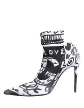 Dolce & Gabbana white stretch ankle boots featuring black hand-painted graffiti print and a sleek pointed toe.