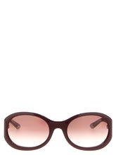 Elülső nézet Gucci női napszemüvegekről, mély borostyánszínű acetátból, sötét árnyalatú lencsékkel és kifinomult, téglalap alakú kerettel.