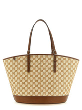 Front view of a Gucci brown cotton handbag featuring the iconic GG monogram pattern and structured leather trim.