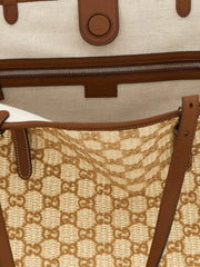 Close-up of the Gucci brown cotton fabric and hardware, showcasing the intricate weave and heritage logo detail.