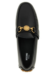 Nahaufnahme der Moschino Slipper mit Fokus auf die glatte Lederstruktur und präzisen Ton-in-Ton-Nähten.