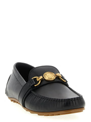 Seitenprofil der schwarzen Leder-Slipper von Moschino, das den niedrigen Absatz und die raffinierte italienische Handwerkskunst zeigt.