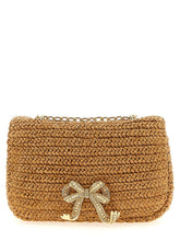 Self-Portrait beige raffia shoulder bag featuring a structured silhouette and signature crystal-embellished bow detail.