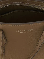 Primer plano del bolso tote de Tory Burch que muestra la veta natural del cuero de vaca marrón y los detalles precisos del hardware.
