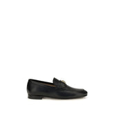 Valentino Garavani black calf leather Bos Taurus slip-on loafers featuring a sleek almond toe and minimalist silhouette.