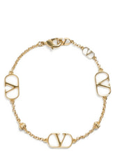Valentino Garavani gold brass cuff bracelet featuring the iconic VLogo Signature emblem in a polished metallic finish.