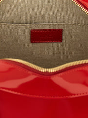 Dettaglio ravvicinato della borsa A.P.C. che illustra la texture della pelle di mucca di pregio e il discreto rilievo del logo in metallo dorato.