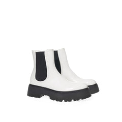 מבט אלכסוני על מגפי צ'לסי של Alexander McQueen מראה סוליית ביניים לבנה פיסולית ועור שחור איכותי.