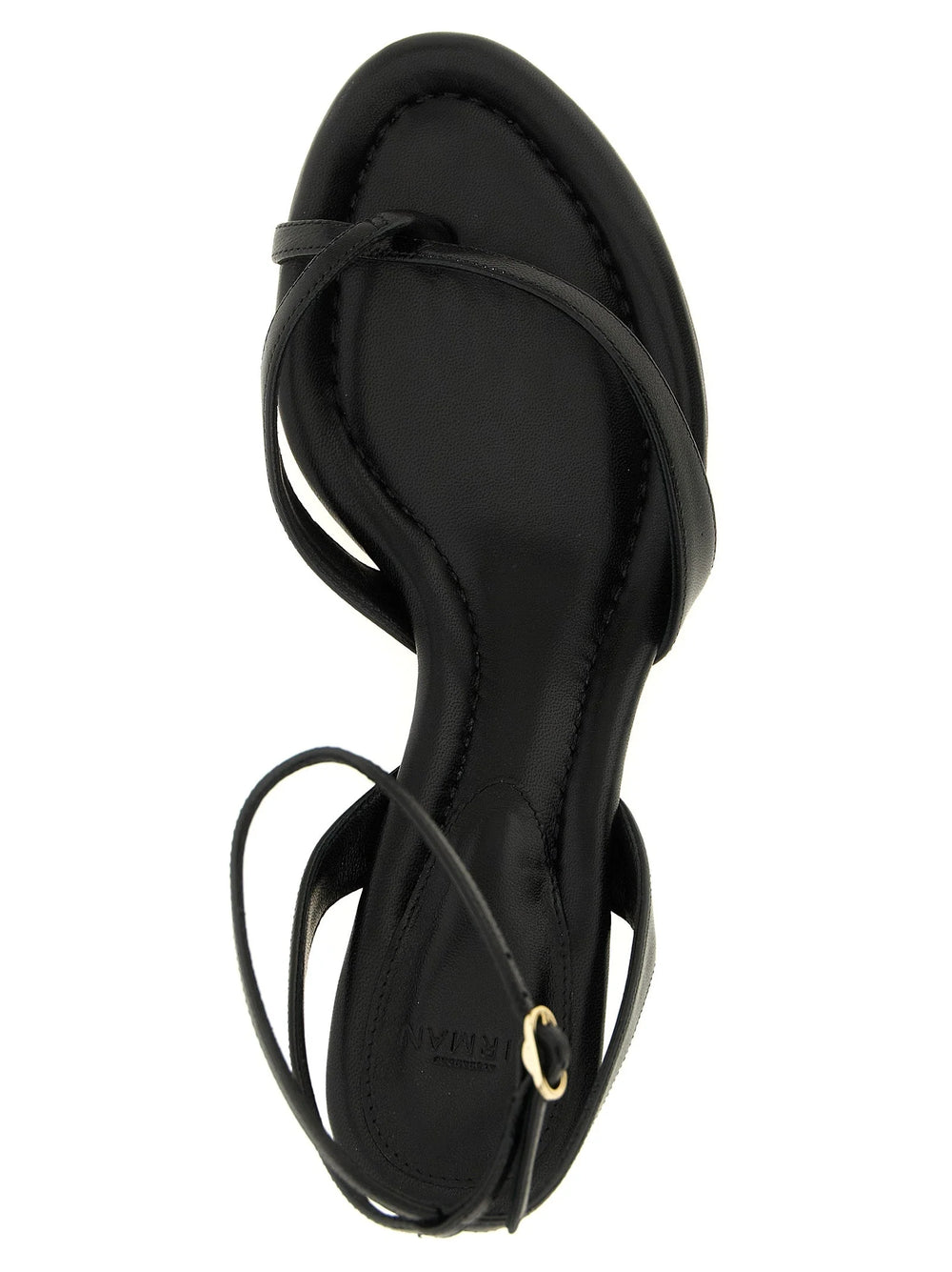 Primo piano della texture premium in pelle di mucca nera e del dettaglio della cinghie annodate a mano sui sandali di lusso Alexandre Birman.