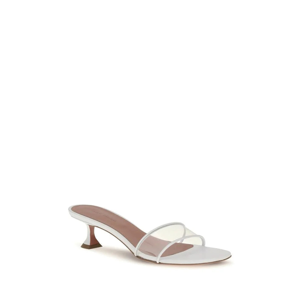 Side profile of Amina Muaddi white leather sandals showcasing the architectural flared heel and delicate ankle strap.