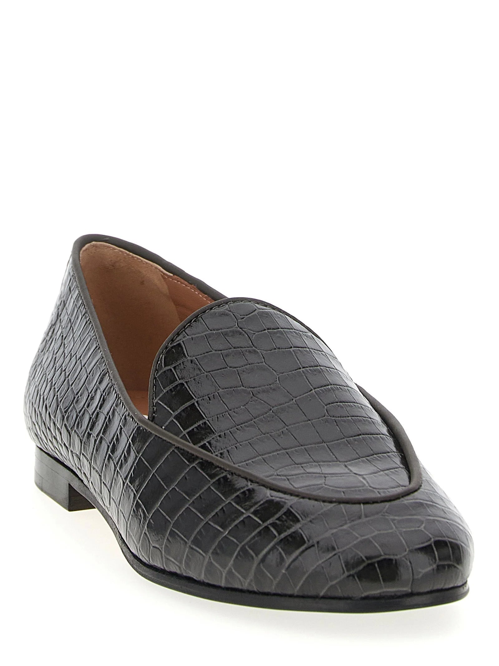פרופיל צד של נעלי העור השחורות של Aquazzura, המציג עקב נמוך ואומנות איטלקית אלגנטית.
