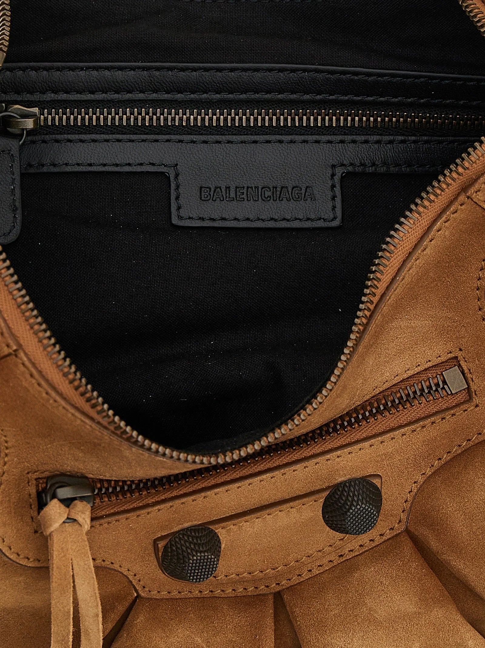Close-up detail of the Balenciaga brown shoulder bag, focusing on the premium calfskin grain and hardware craftsmanship.