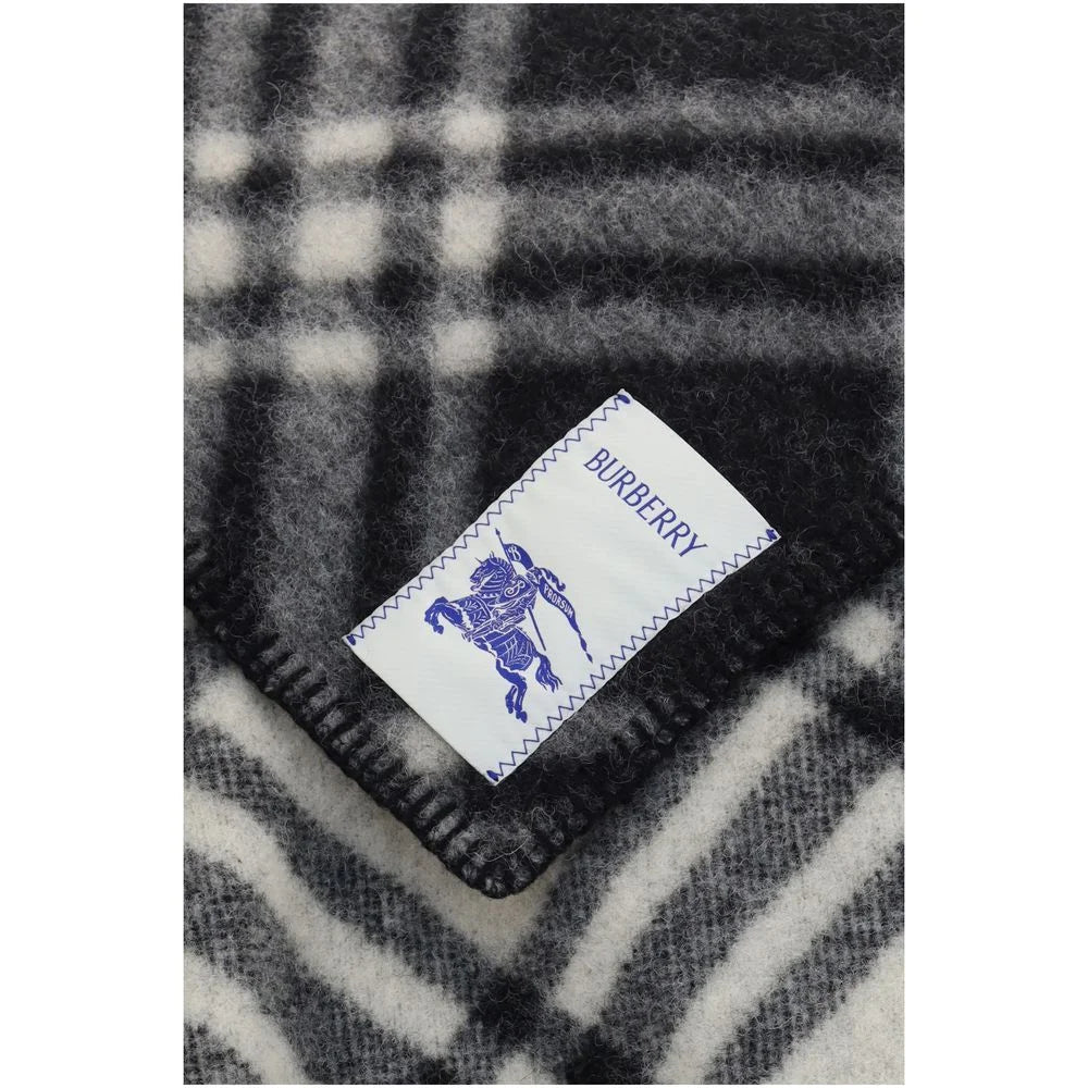 Detailný pohľad na sivý vlnený šál Burberry, ktorý zvýrazňuje zložité pletenie, hotové okraje a autentické označenie značky.