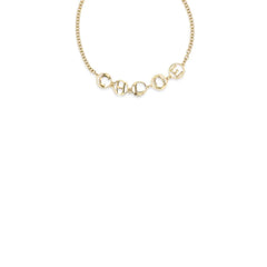 Nahaufnahme des Chloé gold Messingarmbands, die die glatte Textur und die dezente Markenprägung hervorhebt.