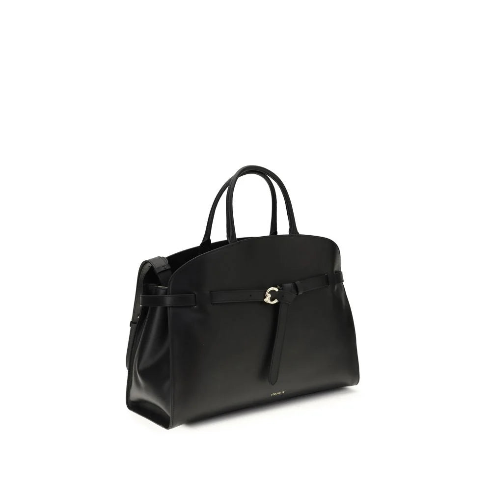 Side profile of the Coccinelle Bos Taurus leather bag in black showing the refined silhouette and gusset detail.