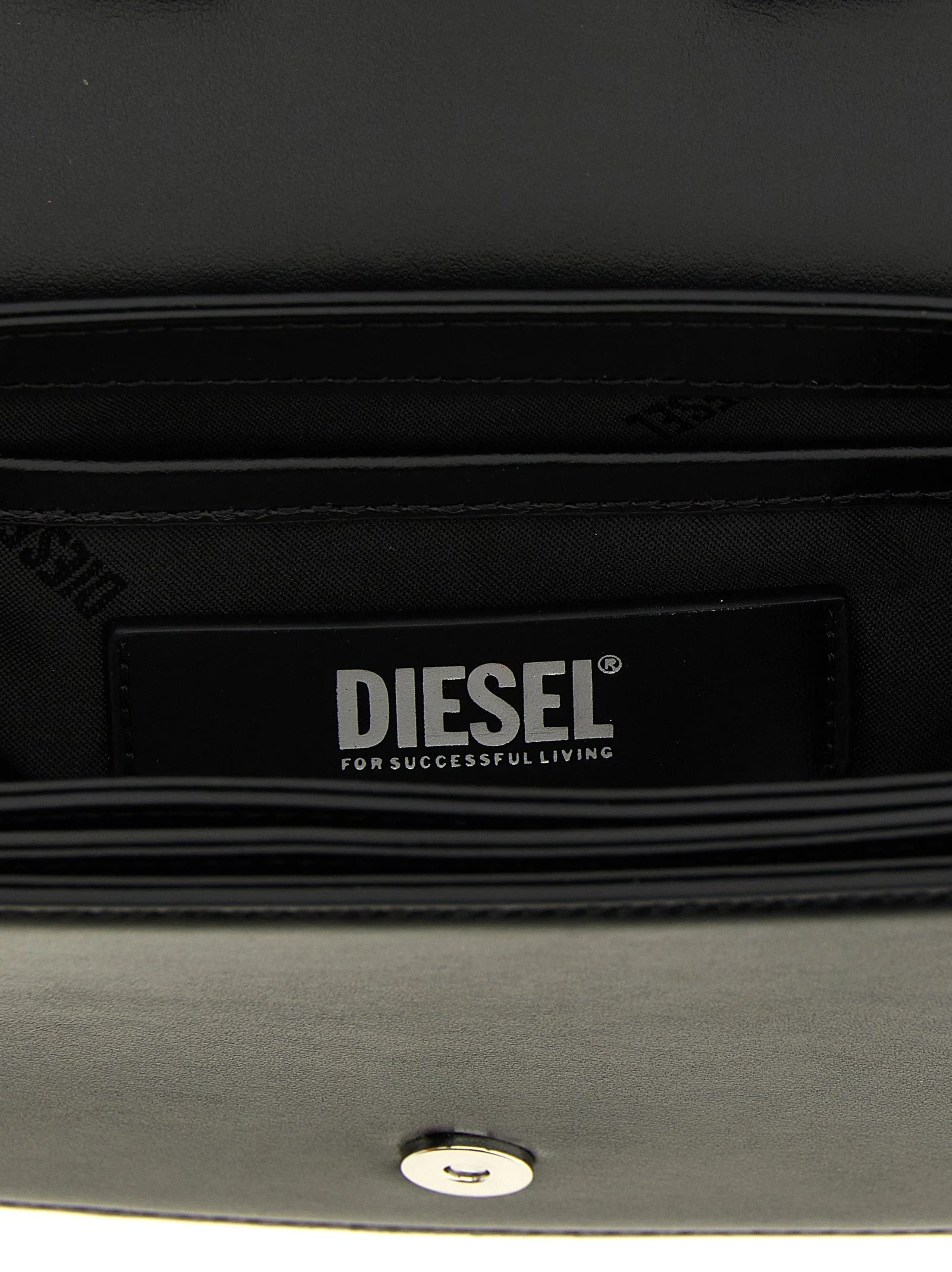 Nærbillede af skuldertasken fra Diesel med fokus på den ædle cowhide-tekstur og det polerede hardware i sølvtoner.