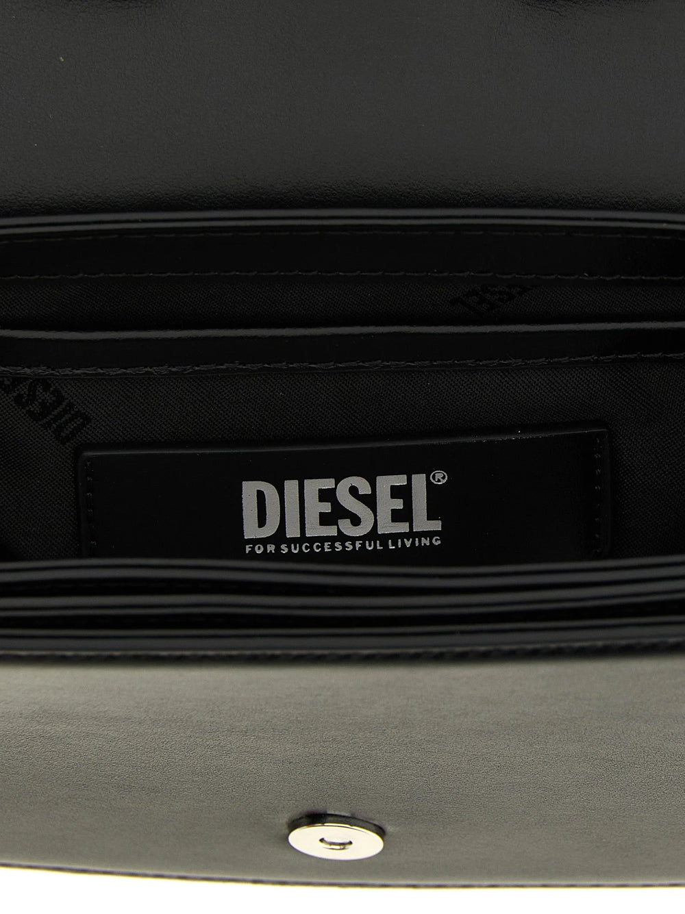 Nærbillede af skuldertasken fra Diesel med fokus på den ædle cowhide-tekstur og det polerede hardware i sølvtoner.