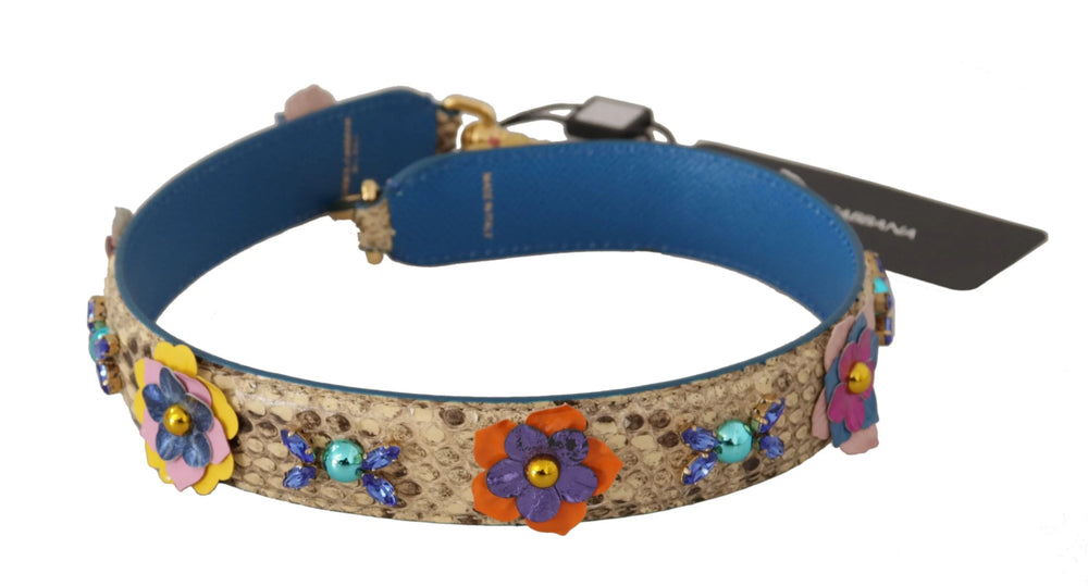Detaliu al clemelor de homar aurii lustruite gravate cu logo-ul Dolce & Gabbana pe o curea de umăr din piele de piton florală.