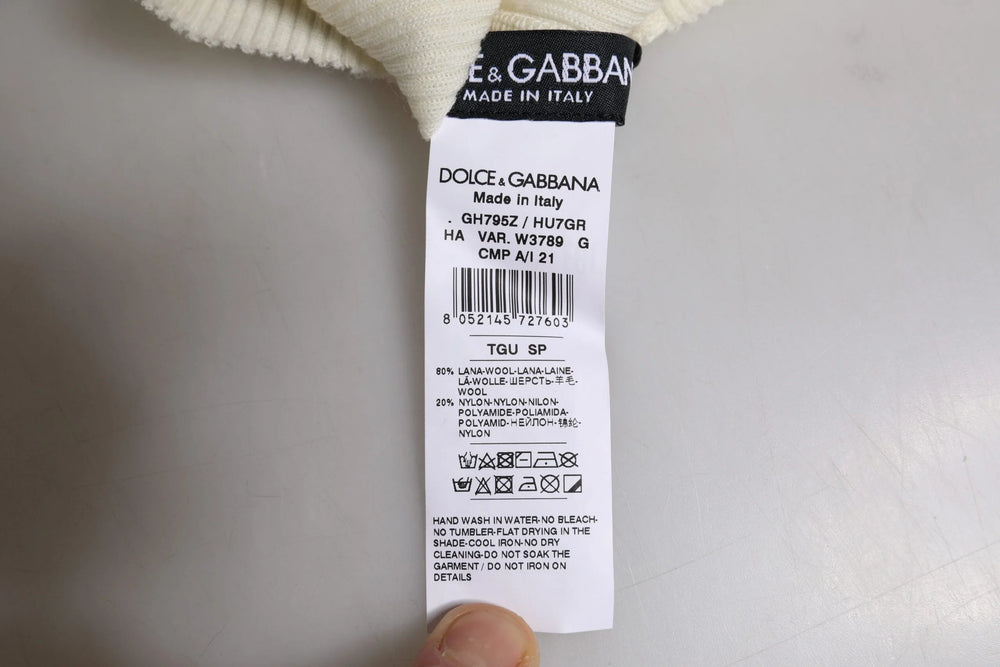 Detailní záběr na vnitřní štítek a měkkou žebrovanou spodní část pletené čepice Dolce & Gabbana pro muže.