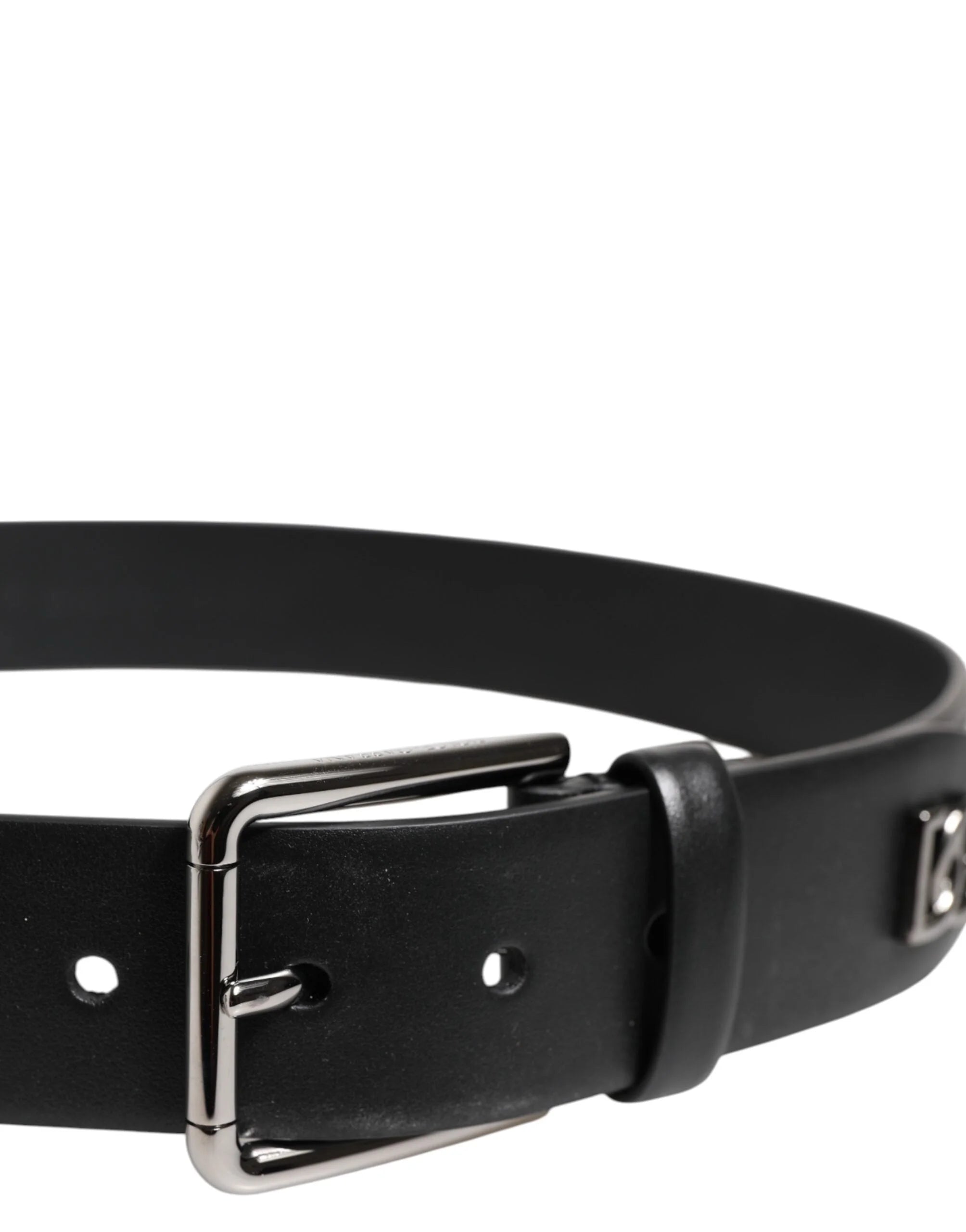 Close-up van de zilverkleurige metalen gesp en de ingewikkelde studding op de zwarte leren riem van Dolce & Gabbana.