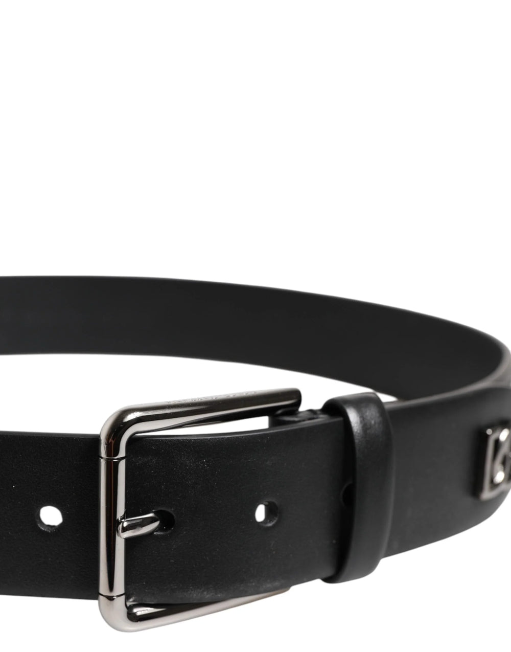 Close-up van de zilverkleurige metalen gesp en de ingewikkelde studding op de zwarte leren riem van Dolce & Gabbana.