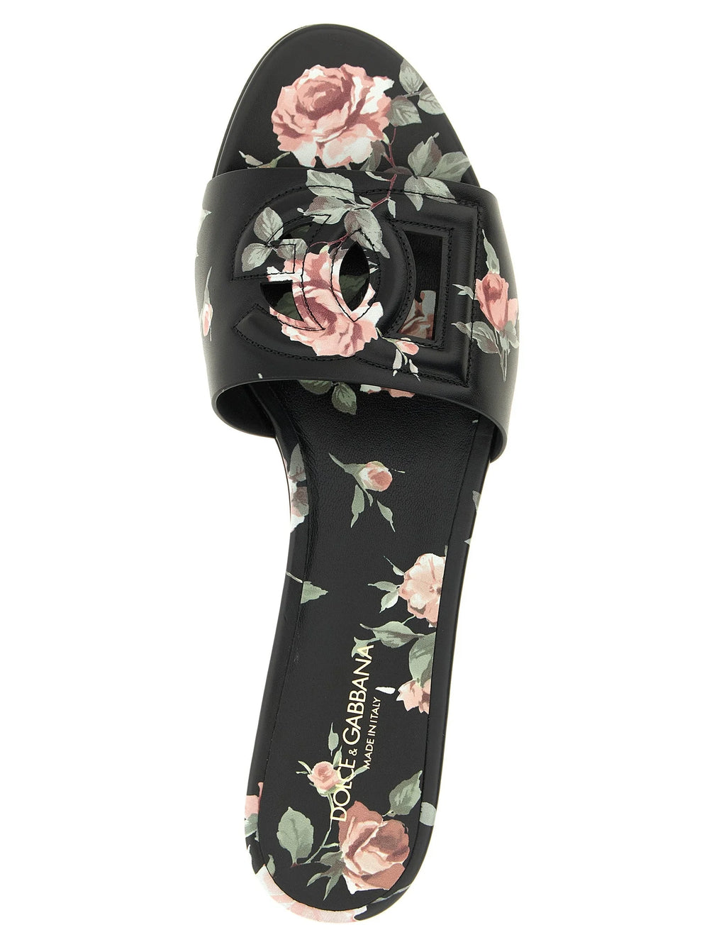Close-up detail van de Dolce & Gabbana zwarte leren slippers, waarbij de fijne korrel en precieze tonale stiksels worden benadrukt.
