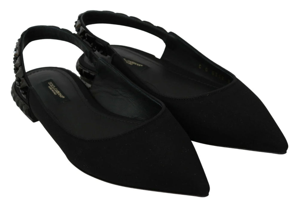 Prise de vue rapprochée de la semelle en cuir lisse et du savoir-faire des mules plates en charmeuse noire Dolce & Gabbana.