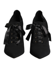 Dolce & Gabbana black lace-up stiletto pumps featuring a pointed toe and elegant wrap-around ankle ties.