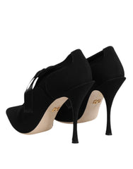 Top-down view of black Dolce & Gabbana pointed-toe pumps with intricate lace-up detailing and branded insoles.