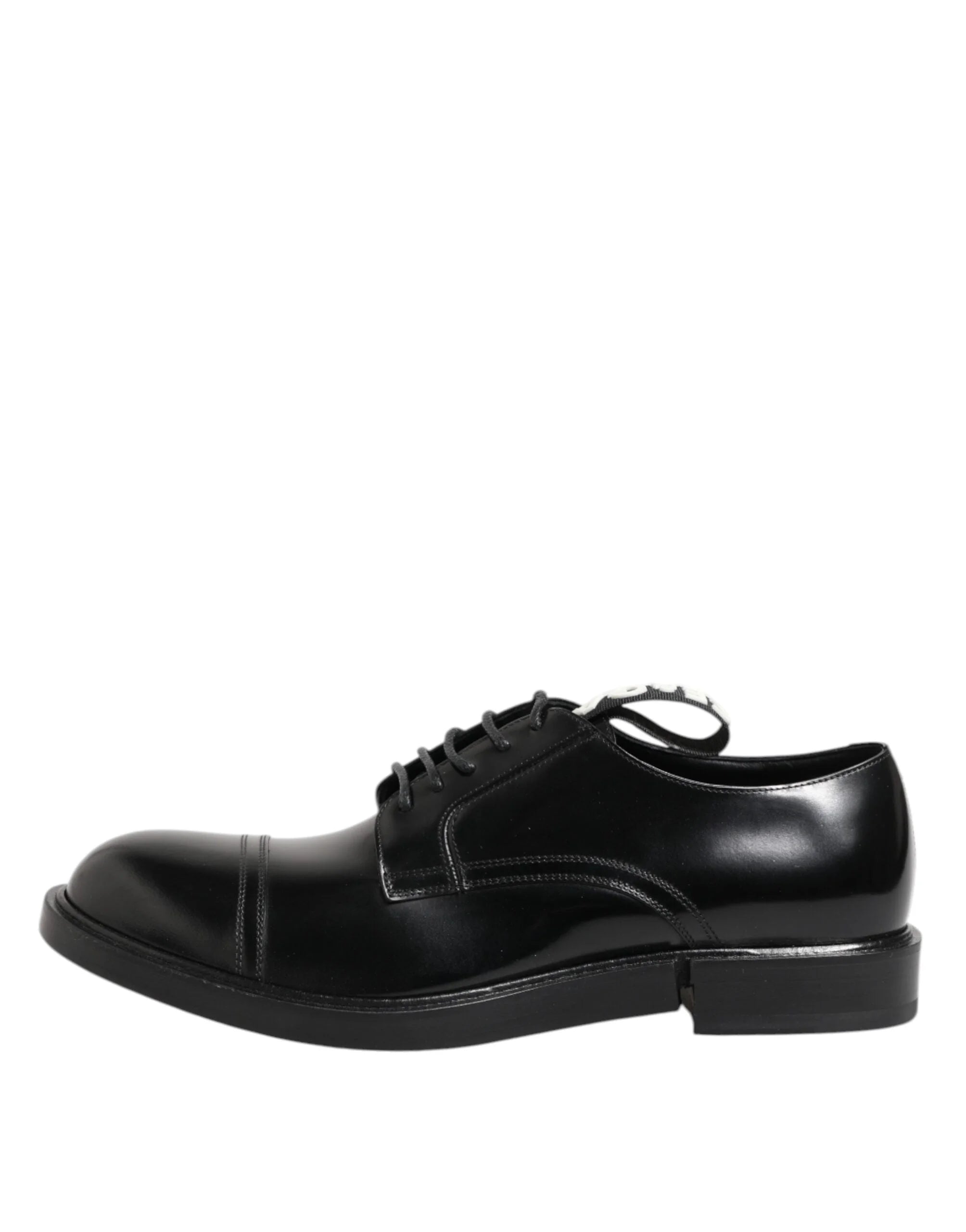 Detailný záber na šnurovanie a jemné stehovanie na čiernych kožených spoločenských topánkach Dolce & Gabbana.